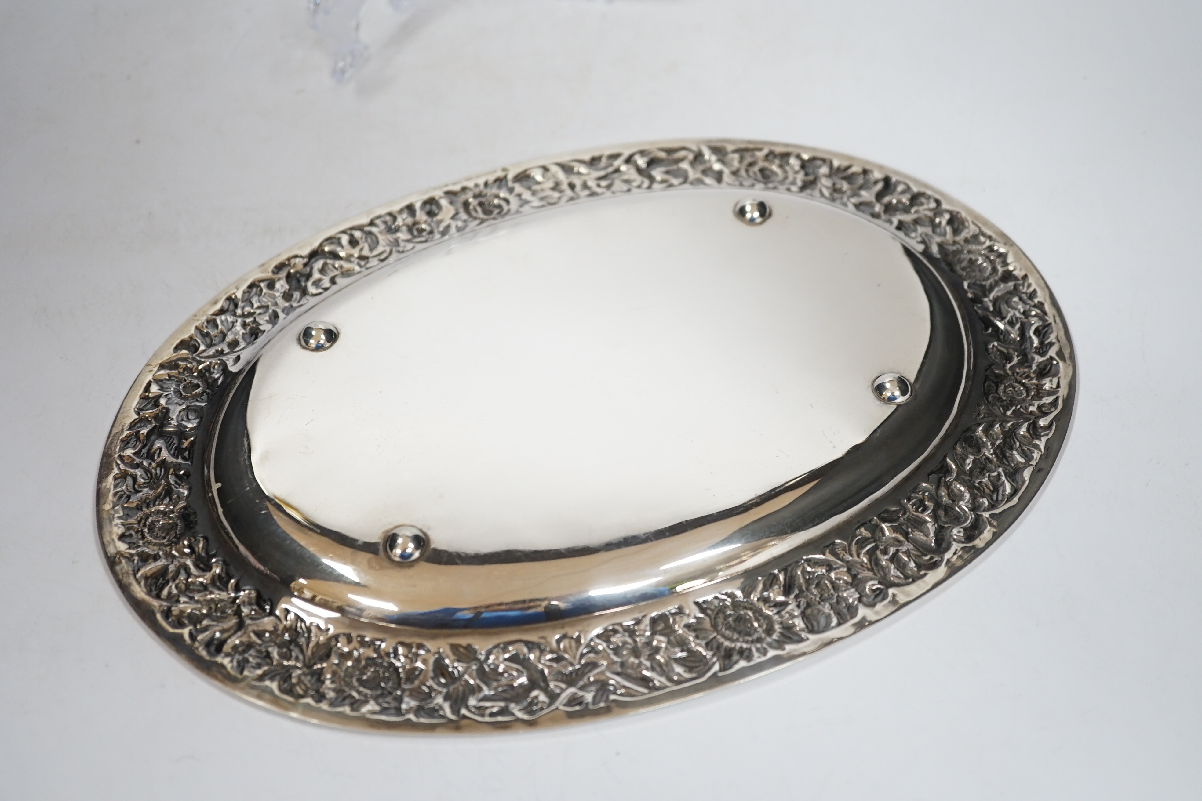 A Thai white metal oval salver, the border decorated with flowers, birds and squirrels, stamped sterling, 31cm